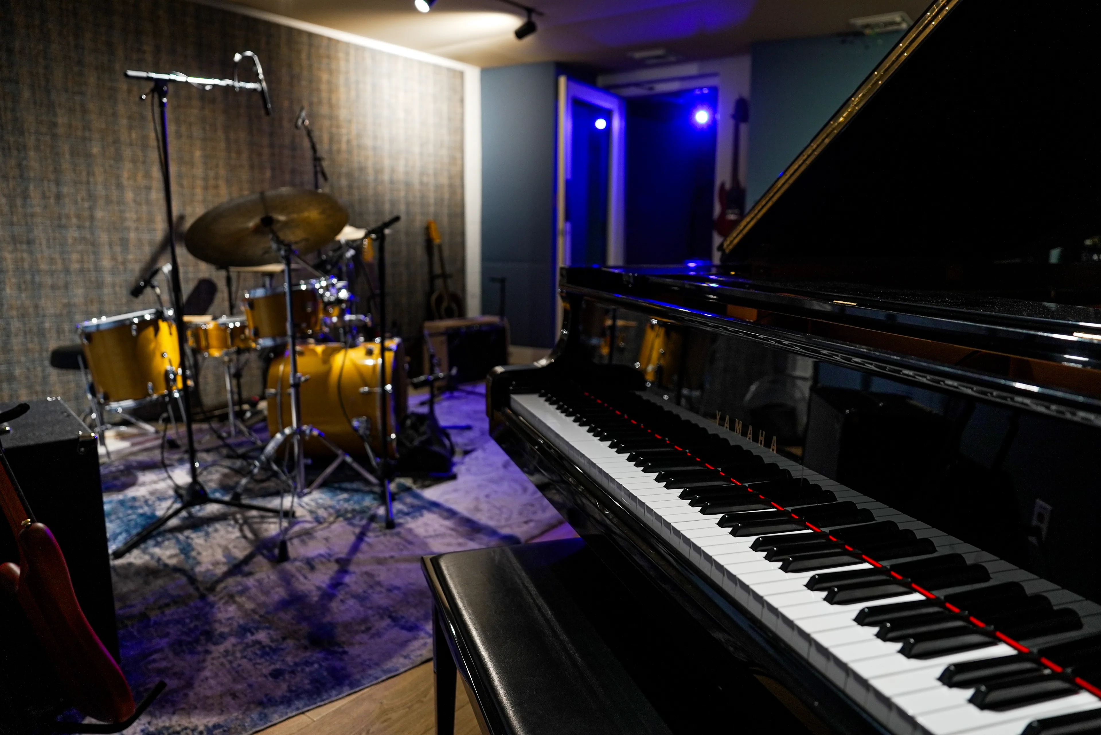 The main tracking room at The Recording Club, with a grand piano and a mic'd drum kit